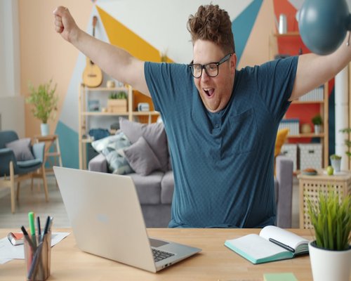 Person stretching arms comfortably while standing near a home office desk