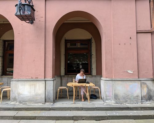 Woman adjusting her sitting posture while working remotely at a cafe in Providencia
